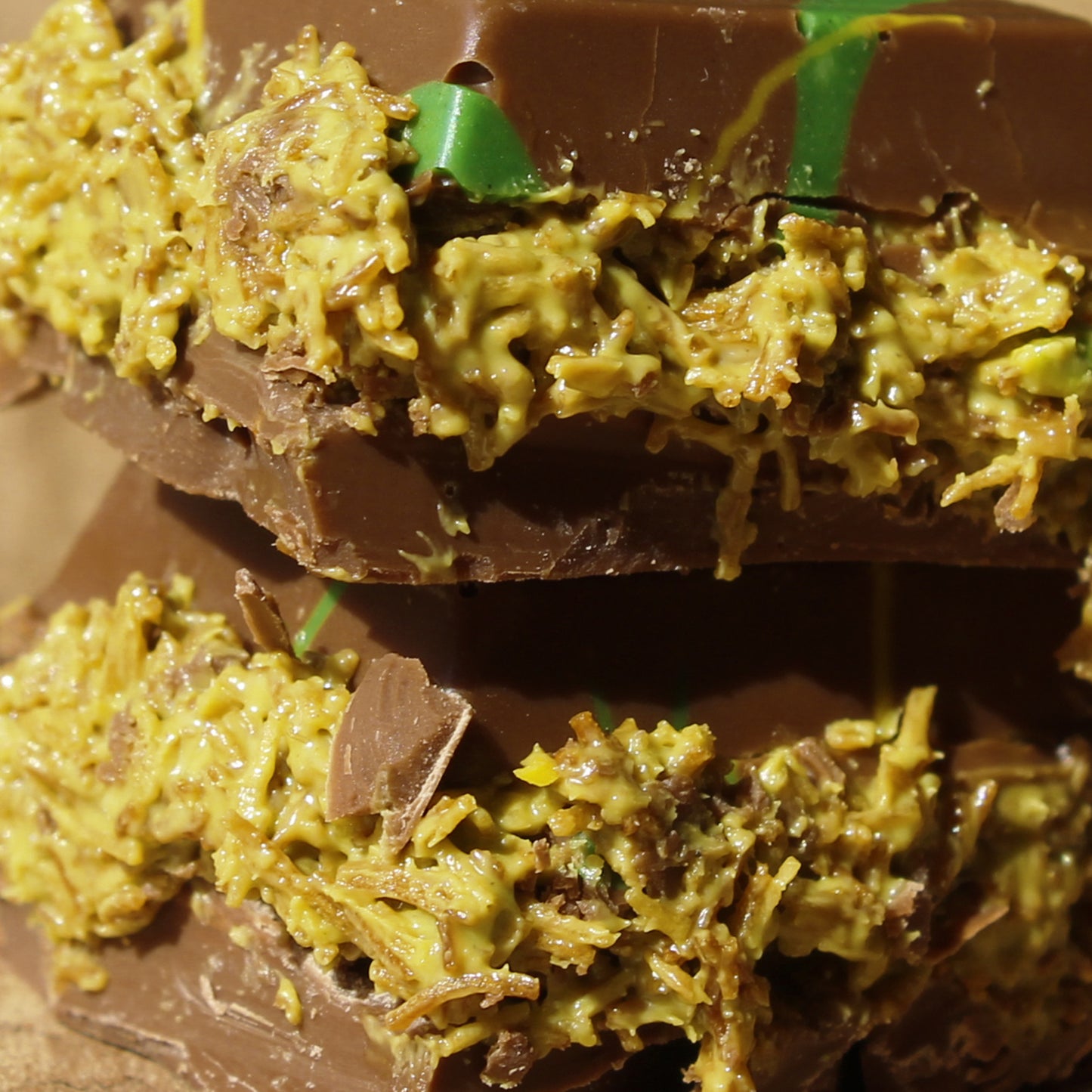 Close-up of two stacked Ceres Gourmet Bulk Size Milky Dubai Chocolate Pistachio Bars—creamy milk chocolate layers with a thick, yellow-green pistachio filling—an irresistible 7oz delight available in packs of 50.