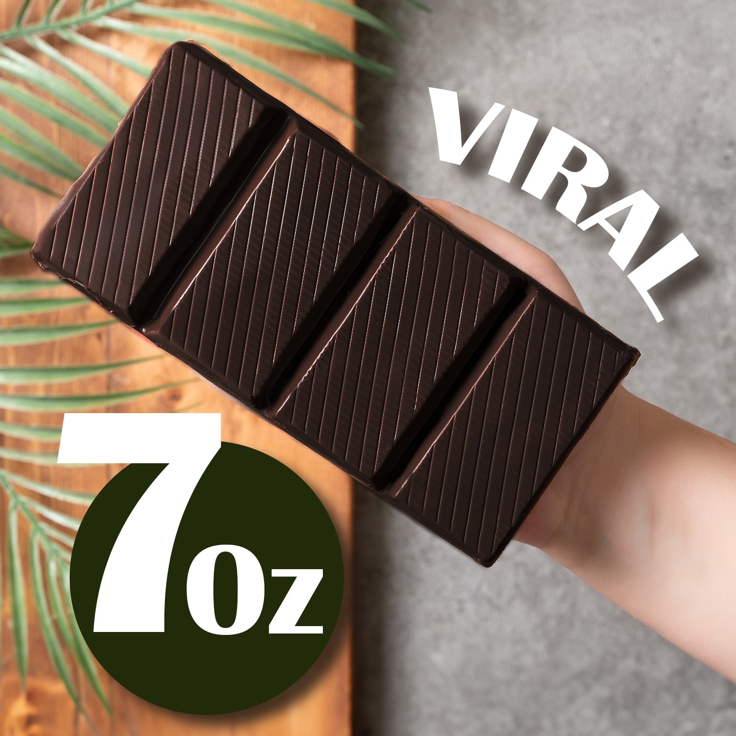 A hand holds a Viral Dubai Chocolate Bar Dark 75% Pistachio by Ceres Gourmet, divided into four sections. VIRAL appears above, with 7 oz in bold white text on a dark green circle. A palm leaf accents the background for this indulgent treat.