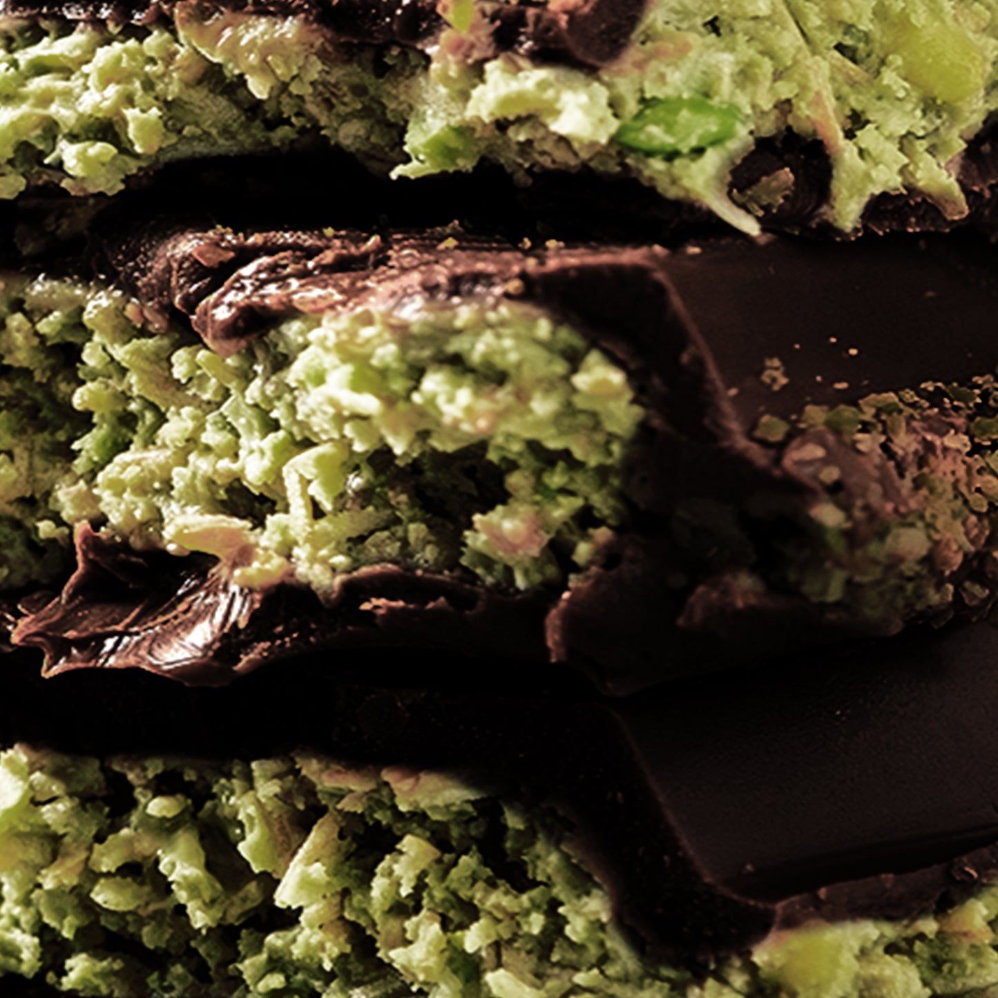 Close-up of stacked Ceres Gourmet Viral Dubai Chocolate Bar Dark 75% Pistachio 7 oz, highlighting the green pistachio kunafa filling, crumbly interior, and smooth dark chocolate coating.