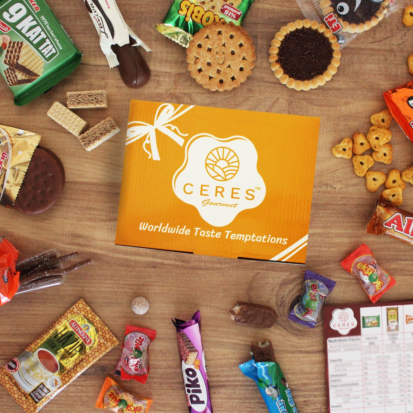 A yellow Ceres Gourmet box is surrounded by 15 premium international snacks and candies from the International Exotic Treats Box, featuring cookies, chocolate bars, crackers, and sweets. The Ceres menu appears in the bottom right corner.