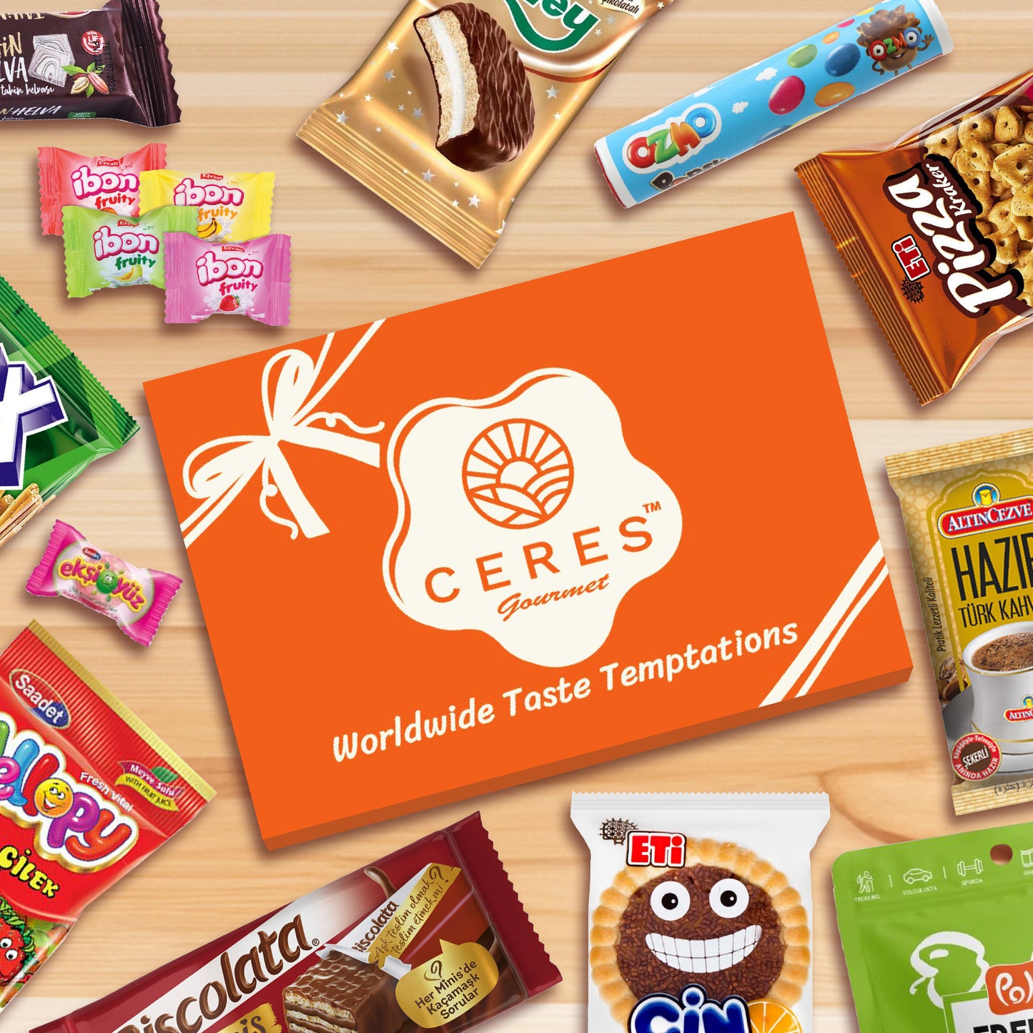 A Ceres Gourmet International Snack Box (12 Different Snacks, 15+ Pieces) with Worldwide Taste Temptations branding sits on a light wooden surface, surrounded by colorful assorted foreign snacks and rare candies.