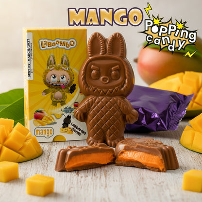 Chocolate candy with a cartoon character packaging, surrounded by mango pieces on a wooden surface.