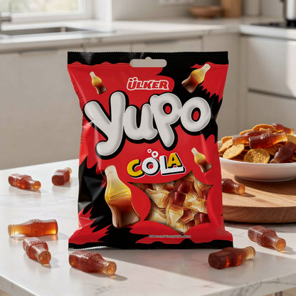 Red package of Ulker Yupo Cola on a kitchen counter with gummy candies around