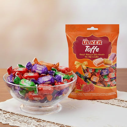 Bowl of colorful candy with a package of Ulker Toffe candies on a white surface.