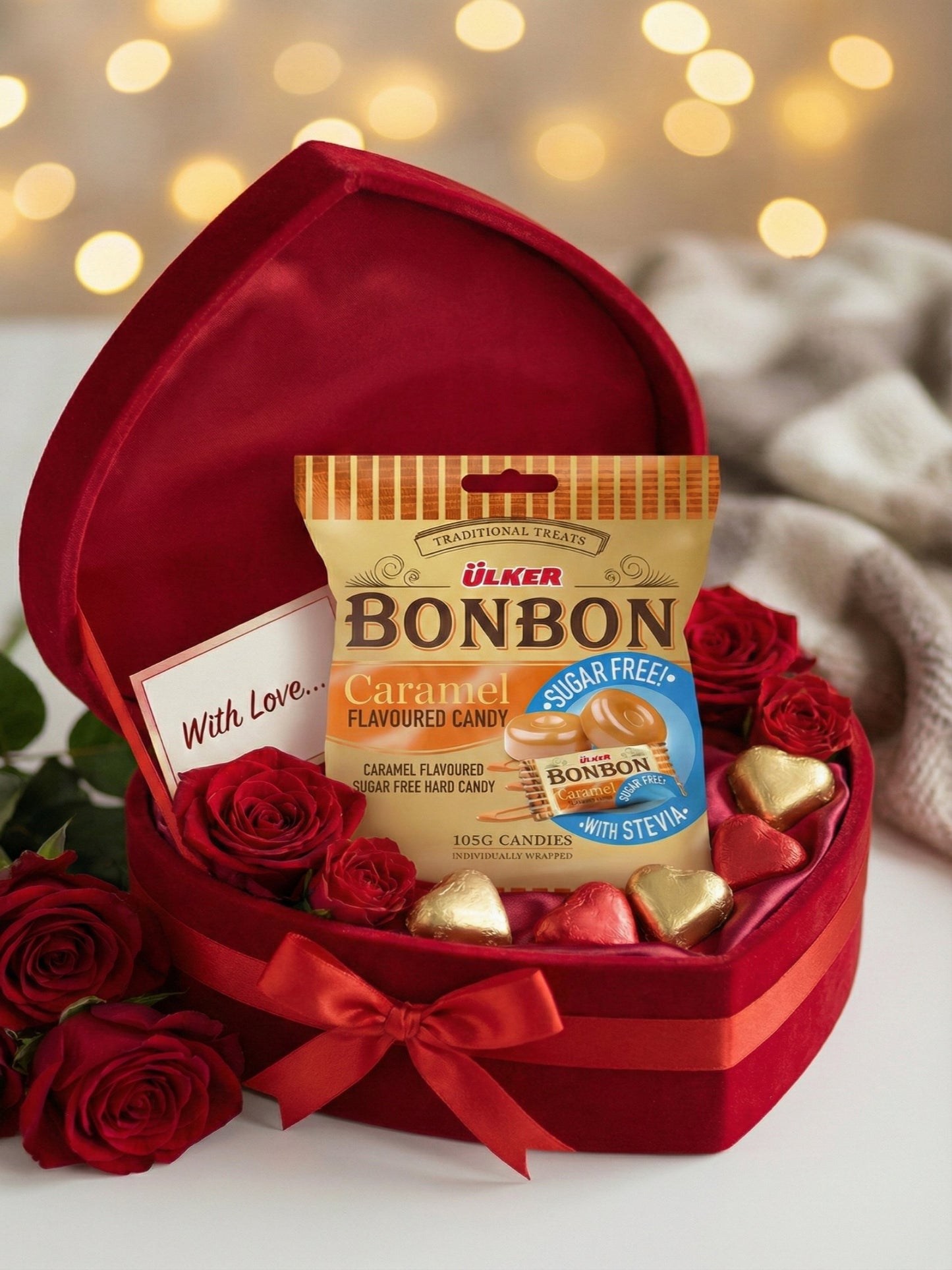 Heart-shaped gift box with Ulker Bonbon candy and red roses on a blurred background