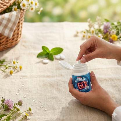 Hand holding a blue container labeled 'ONEO' with flowers and a basket in the background