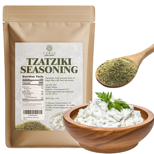A Ceres Gourmet Authentic Greek Tzatziki Dip Spice Blend 4 oz package sits beside a wooden spoon with green seasoning and a bowl of creamy tzatziki dip topped with fresh dill.