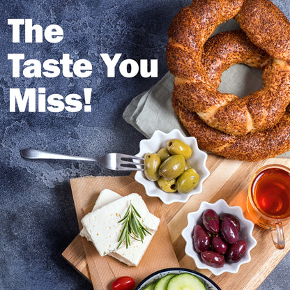 Bread, olives, cheese, and tea on a wooden board with 'The Taste You Miss!' text.