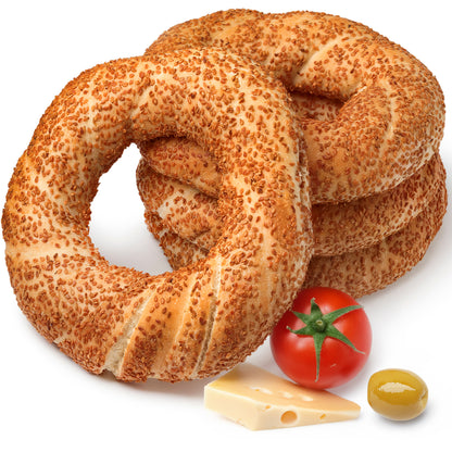 Stack of sesame seed bagels with a tomato, cheese, and olive on a white background