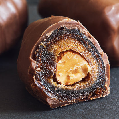 Close-up of Ceres Gourmet Dark Chocolate Coated Medjool Dates Stuffed with Almonds, cut to show the almond center, surrounded by glossy chocolate—delicious and healthy, available in 2 packs (8.46 oz).