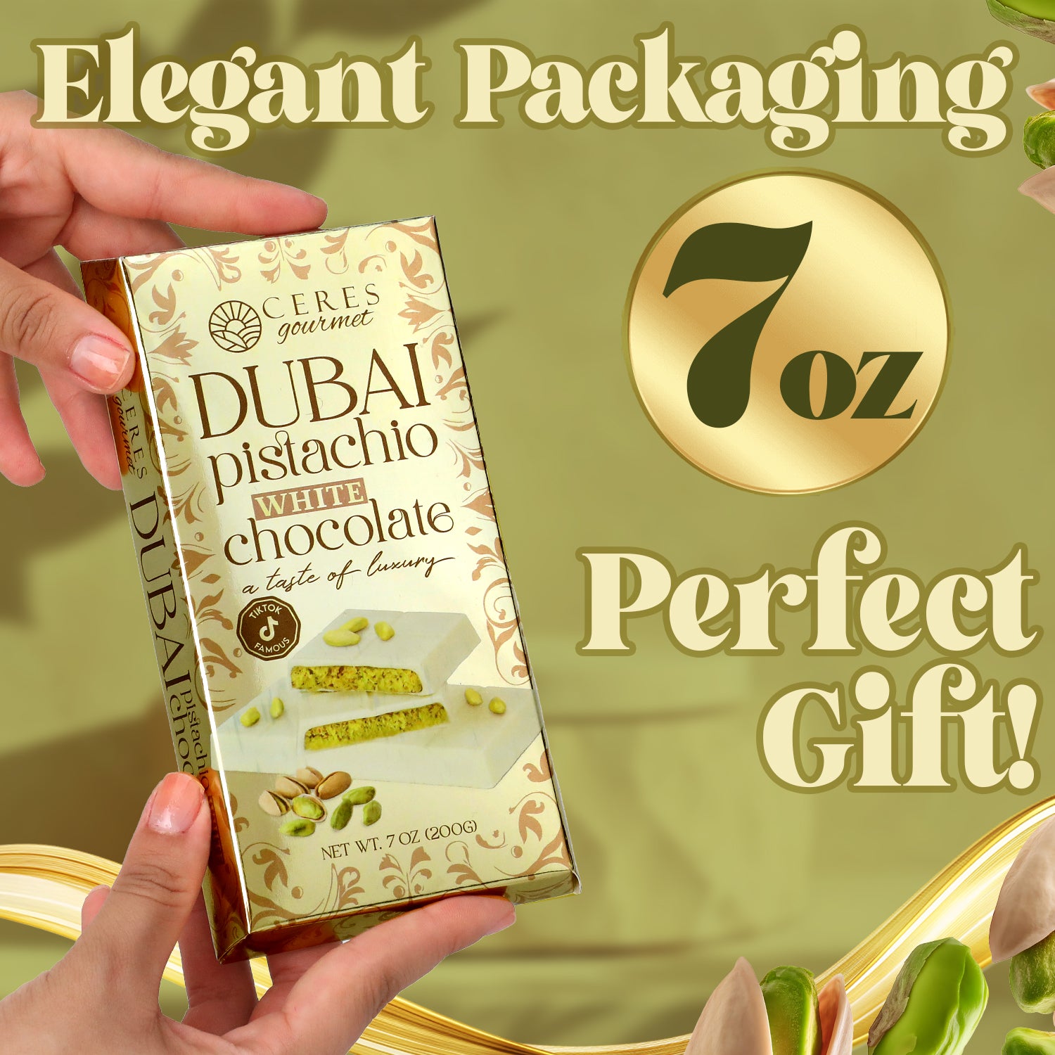 A hand holds a Ceres Gourmet White Dubai Chocolate Crispy Knafeh Pistachio Bar 7oz. Text reads Elegant Packaging, Perfect Gift! with pistachios and gold accents in the background. Enjoy a taste of crispy knafeh in every bite.