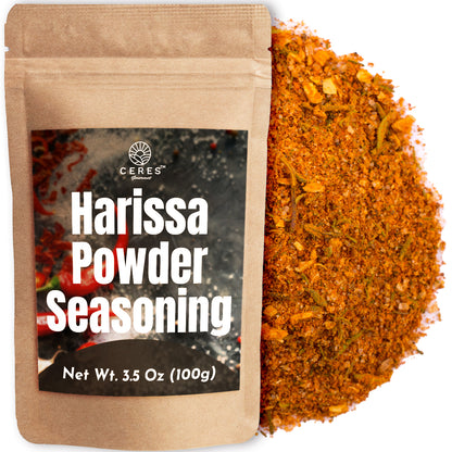 A Ceres Gourmet Harissa Seasoning Blend pouch (3.5 oz), labeled Aromatic & Mildly Spicy Harissa Powder, sits next to a pile of orange-red North African spice mix with visible dried herbs and spices.