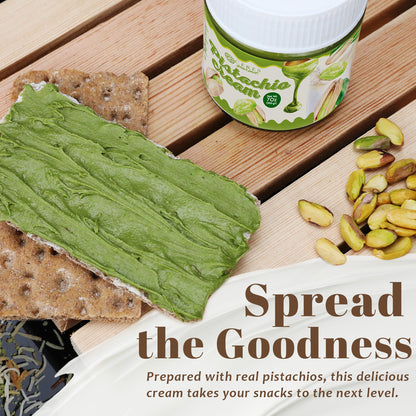 Pistachio cream spread on a cracker with pistachios on a wooden surface, featuring a container of the product.
