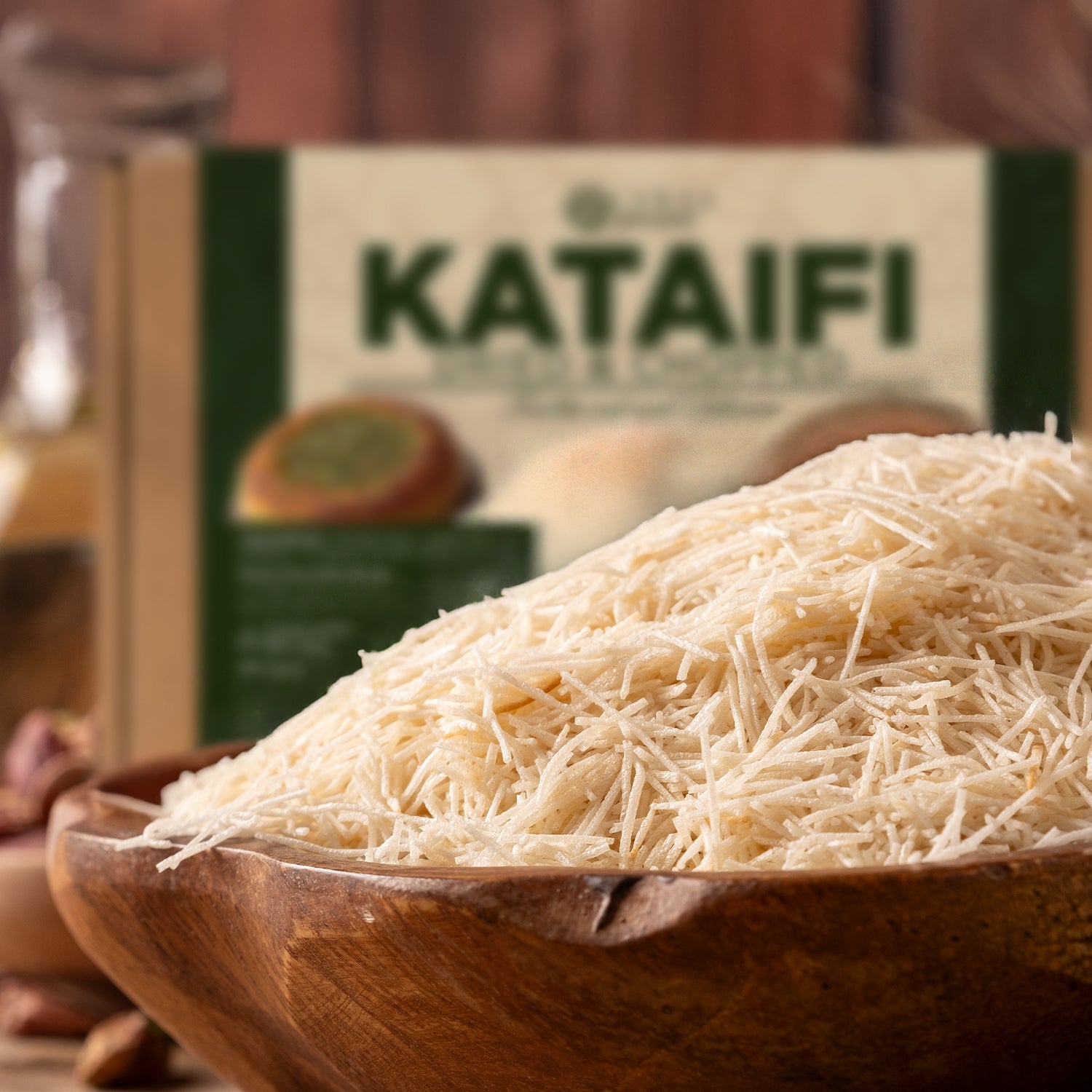 A wooden bowl filled with uncooked Premium Kataifi Shredded Fillo Dough – 3.5oz (100g) by Ceres Gourmet sits in the foreground, with a blurred KATAIFI package visible in the background.