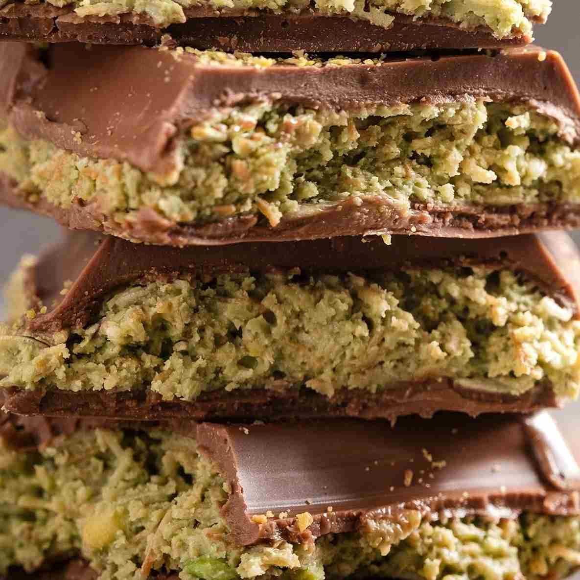 Close-up of stacked Ceres Gourmet Viral Halloween Dubai Chocolate Bars, 75% Pistachio-7 oz, revealing their green pistachio cream filling, creamy handcrafted chocolate coating, and crunchy texture.