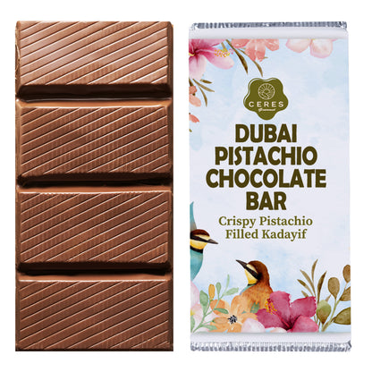 A chocolate bar with diagonal lines is shown beside its wrapper, labeled Ceres Gourmet Viral Halloween Dubai Chocolate Bar, 75% Pistachio-7 oz, and decorated with colorful floral and bird illustrations.