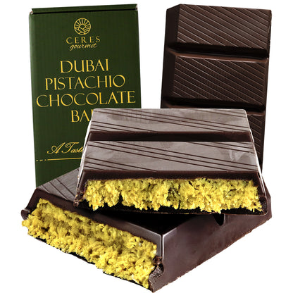 A partially unwrapped Viral Dubai Chocolate Bar Dark 75% Pistachio 7 oz by Ceres Gourmet is shown broken into pieces, with its green packaging visible.