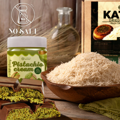 Pistachio cream jar, dried pistachios, and chocolate bar on a wooden surface with 'No Salt' label.